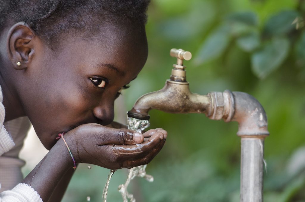 African Child Drinking Fresh Water From Tap
