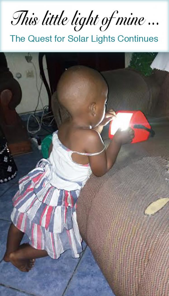 This little light of mine . . . The quest for solar lights continues. Little Congolese girl holding a solar light leaning on tattered sofa.