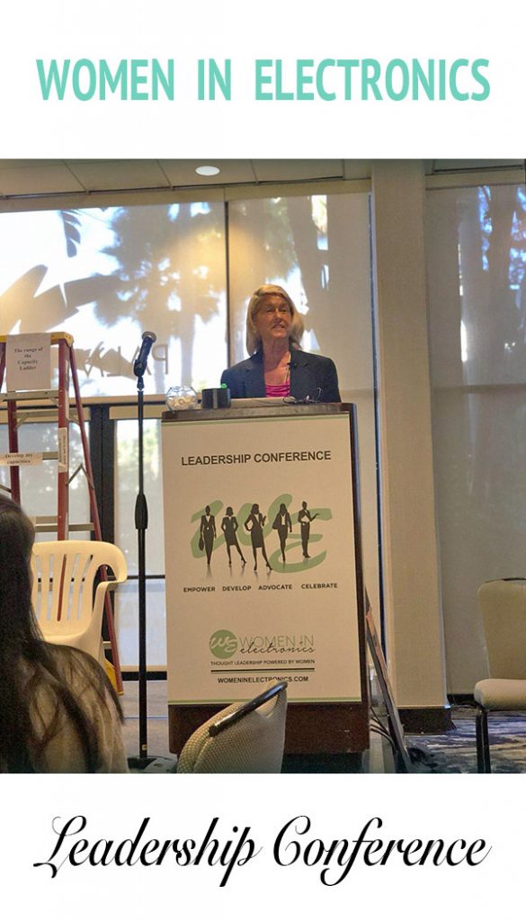 Anastasia Hansel speaking at the Women in Electronics Leadership Conference. She is standing at a podium.