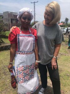 Anastasia with her arm around one of the teen mother students dressed in her culinary uniform.