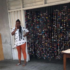 Congolese woman standing in front of her beverage bar.