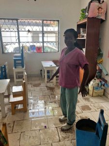 Teen mom standing by the classroom floor she is cleaning.