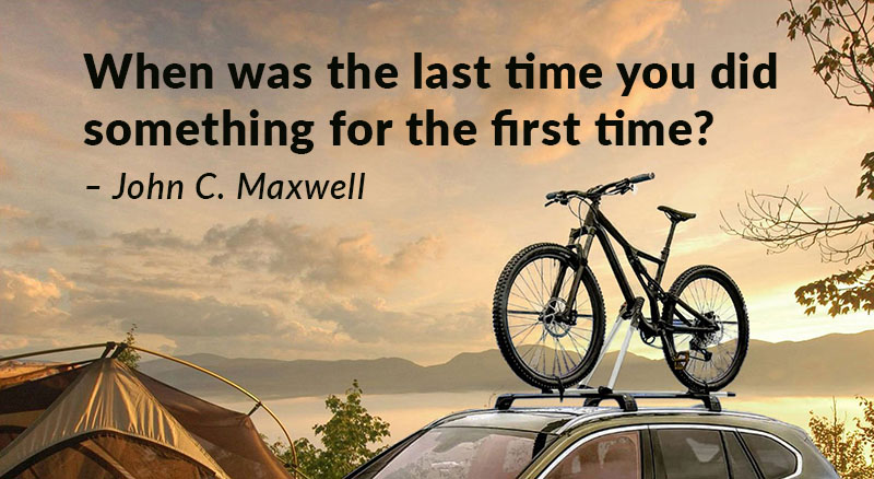 Bike on roof of car near a tent with the John C Maxwell quote, When was the last time you did something for the first time?
