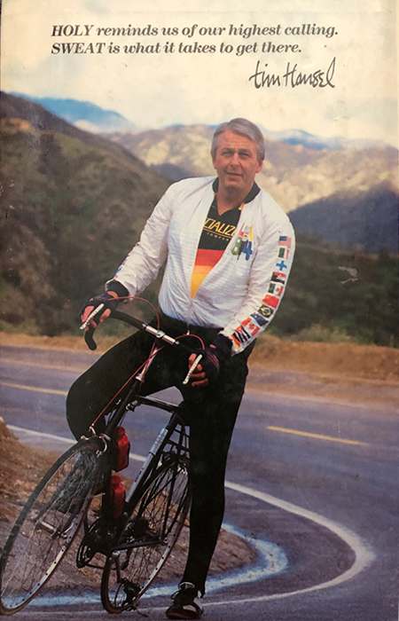 Photo of Tim Hansel on his bicycle, on a road.