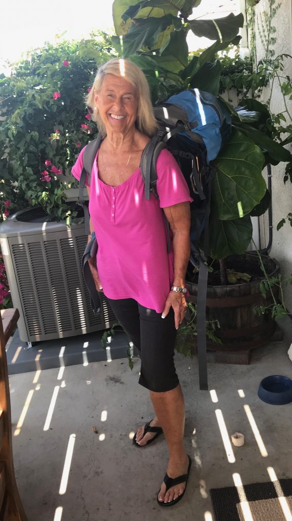 Anastasia Hansel standing in pink shirt with backpack on.